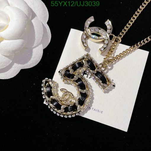 Gold chain necklace with black pendant and white flower.