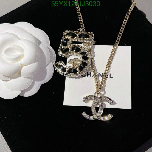 Chanel pendant necklace with flower on black background.