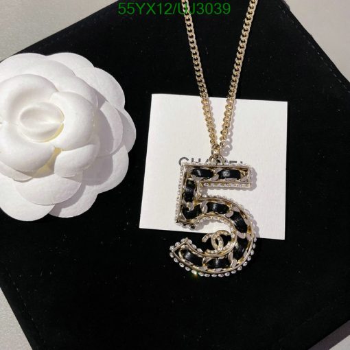 Gold necklace with number 5 pendant and white flower.