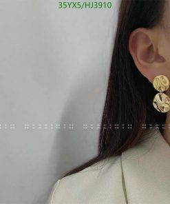 Woman showcasing elegant gold earrings.