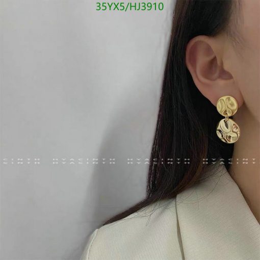 Woman showcasing elegant gold earrings.