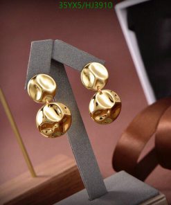 Gold orb-patterned earrings on display stand.