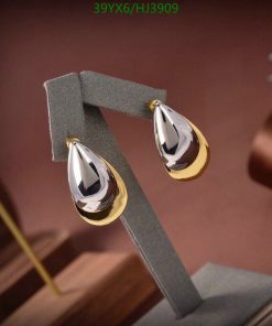 Elegant teardrop gold earrings on display stand