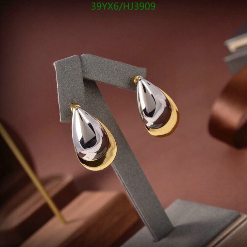 Elegant teardrop gold earrings on display stand