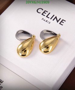 Gold teardrop earrings on white Celine box.