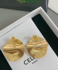 Gold designer earrings on white display box.