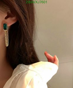 Woman wearing emerald tassel earring.