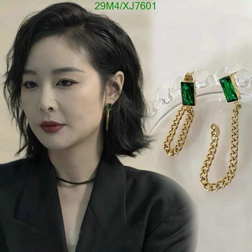 Woman with elegant green earrings and black outfit.