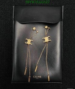 Designer moon-themed gold earrings on black leather pouch.