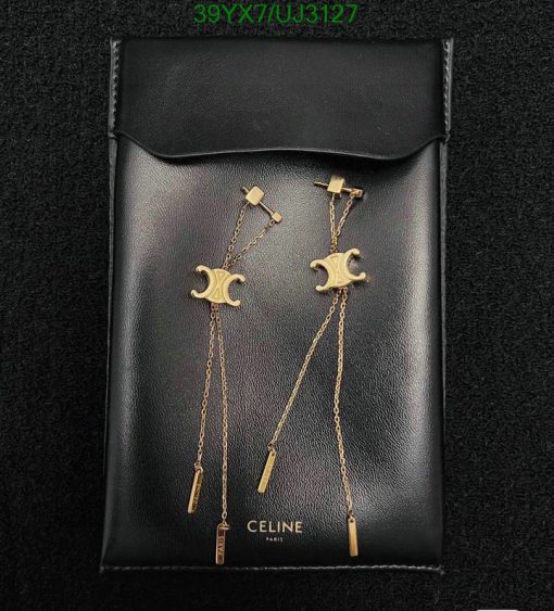 Designer moon-themed gold earrings on black leather pouch.