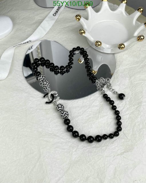 Black beaded necklace with silver accents on white surface.