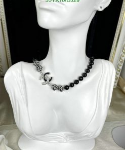 Elegant black pearl necklace on white mannequin display.