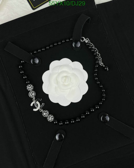 Black bead necklace with white flower pendant.