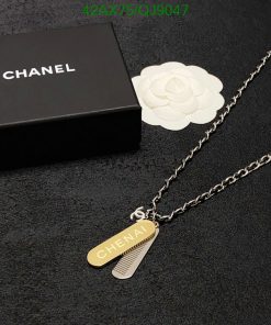 Chanel-branded necklace on black surface with packaging box.