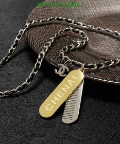 Personalized comb pendant with chain on fabric surface.