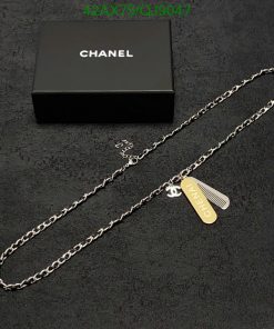 Chanel necklace with logo pendant on dark background.