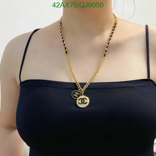 Woman wearing a gold pendant necklace.