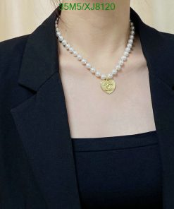 Elegant pearl necklace with gold pendant on black attire