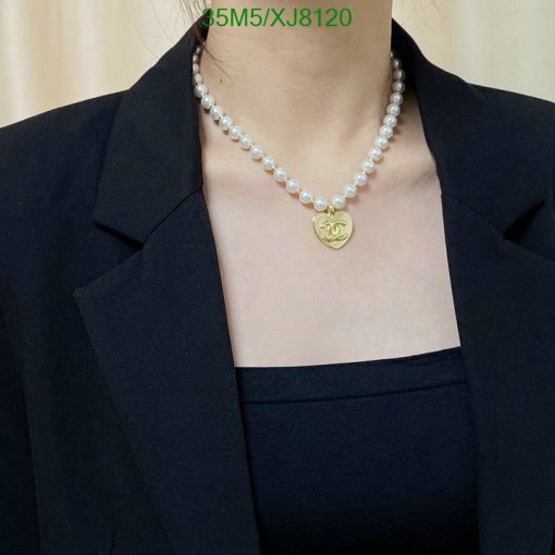 Elegant pearl necklace with gold pendant on black attire