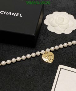 Pearl necklace with gold pendant near luxury brand box.