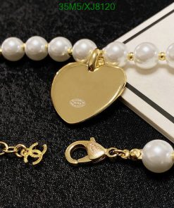 Gold heart pendant on pearl bracelet.