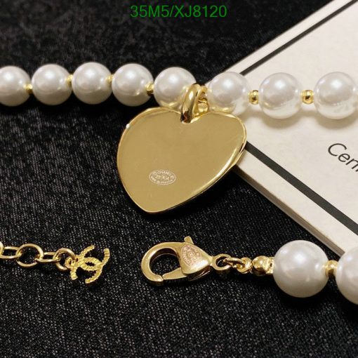 Gold heart pendant on pearl bracelet.