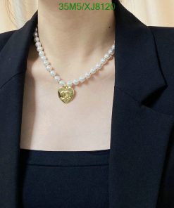 Pearl necklace with gold heart pendant on model.