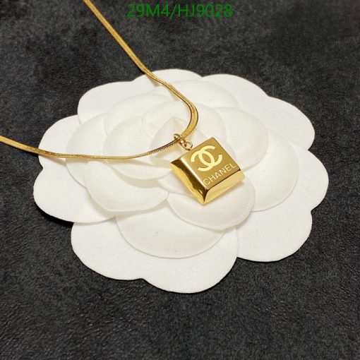 Designer gold pendant necklace on white flower display.