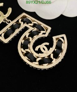 Gold-toned earrings with black accents on dark background.