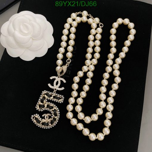 Pearl necklace with white flower and pendant.