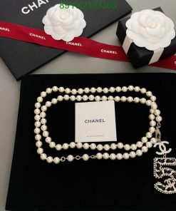 Chanel pearl necklace with logo on black background.