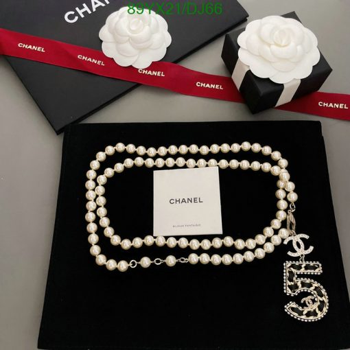 Chanel pearl necklace with logo on black background.