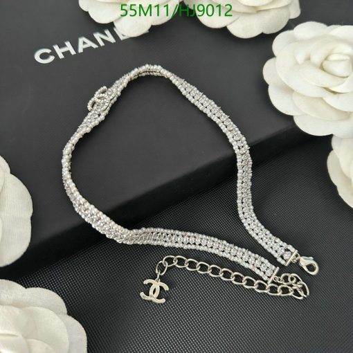 Elegant rhinestone bracelet on black background with white flowers.