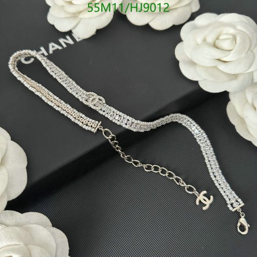 Diamond bracelet on black background with white flowers.