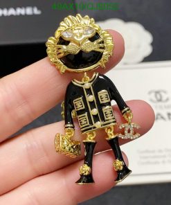 Chanel brooch shaped like a person with sunglasses and logo.