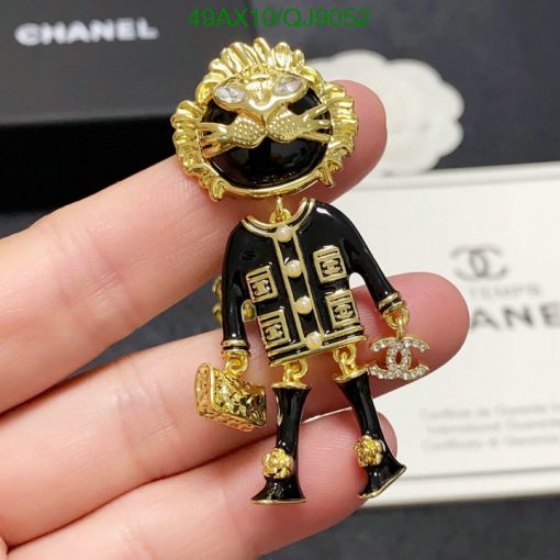 Chanel brooch shaped like a person with sunglasses and logo.