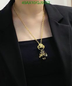 Gold astronaut pendant necklace on black attire.