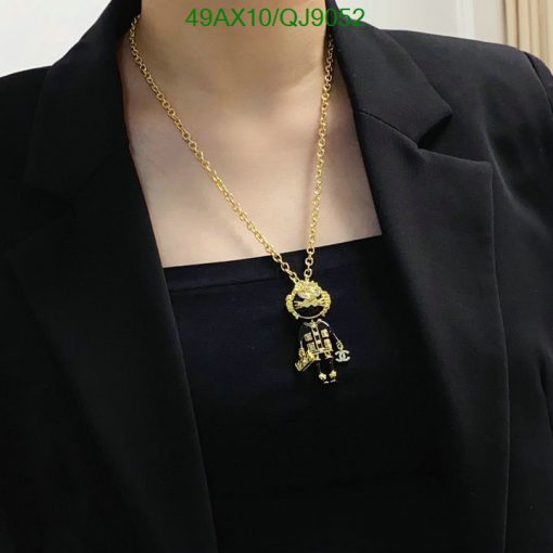 Gold astronaut pendant necklace on black attire.