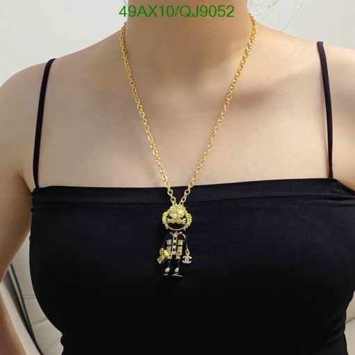 Woman wearing gold robot pendant necklace.