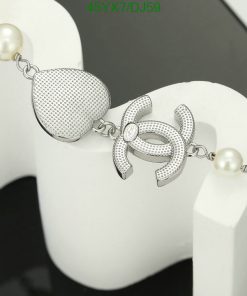 Silver pearl bracelet with decorative pin design.