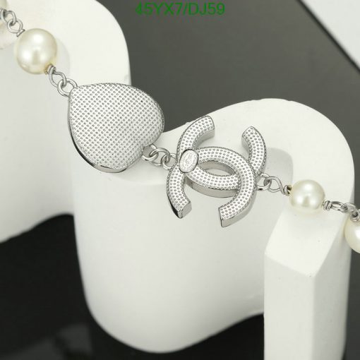 Silver pearl bracelet with decorative pin design.