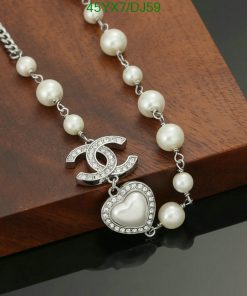 Elegant pearl necklace with heart pendant on wooden surface.