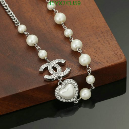 Elegant pearl necklace with heart pendant on wooden surface.