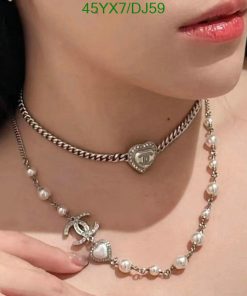 Woman wearing pearl and silver necklaces.