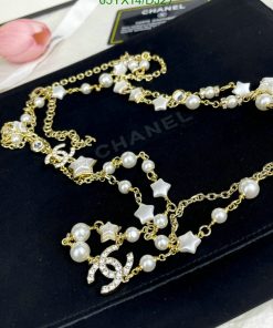 Elegant pearl and star gold-tone necklace on black surface.