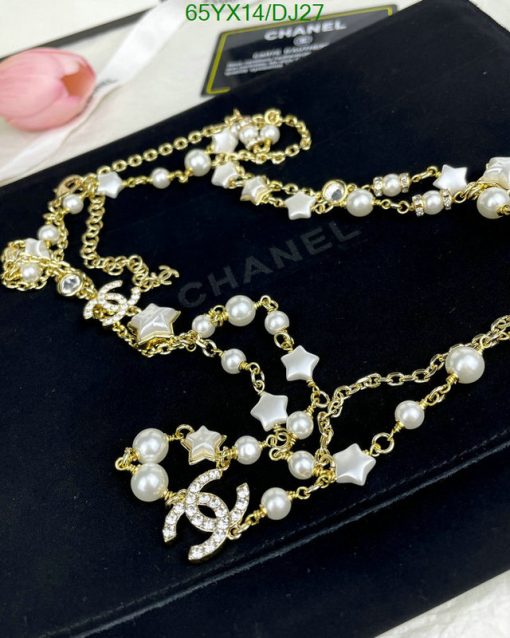 Elegant pearl and star gold-tone necklace on black surface.