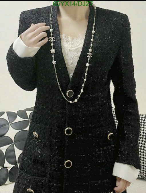 Woman wearing elegant black tweed jacket with pearl necklace.