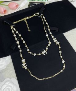 Elegant pearl and star charm gold necklace on black backdrop.