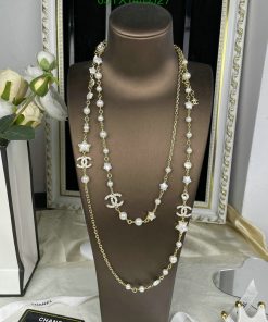 Elegant pearl and gold necklace display on bust.