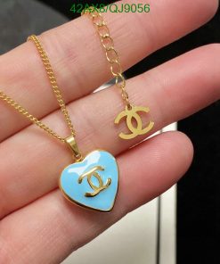 Gold pendant necklace with heart charm held in hand.